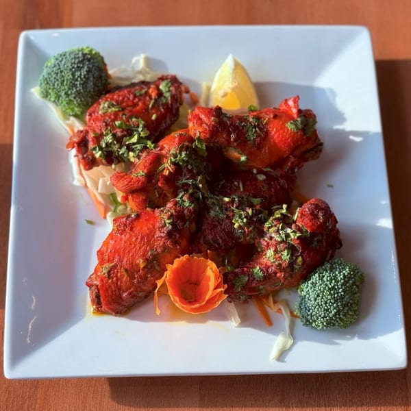 Amrut: Taste of India's Tandoori Chicken, garnished with cilantro, broccoli, and a lemon wedge.